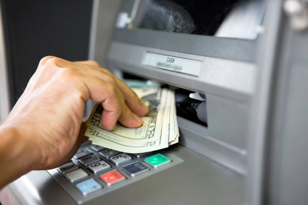 Person pulling money out of an ATM machine.